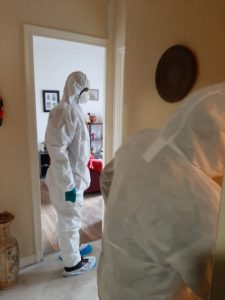 équipe en combinaison pour nettoyer après un décès